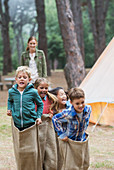 Children having sack race at campsite