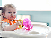 Baby girl playing with sippy cup