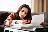 Girl doing homework at coffee table
