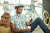 Man in bicycle helmet using cell phone