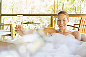 Woman drinking champagne in bubble bath