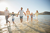 Family walking in shallow water on beach