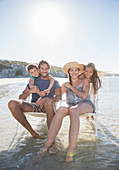 Family sitting in chairs in waves