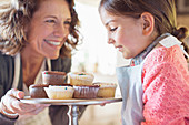 Grandmother offering granddaughter cakes