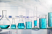 Beakers with solution on shelf in lab