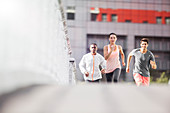 Friends running through city streets