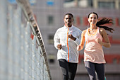 Friends running through city streets