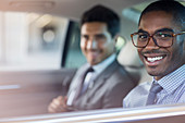 Smiling businessmen sitting in car