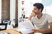 Businessman looking at documents in cafe