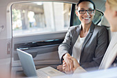 Businesswomen shaking hands in car