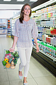 Woman carrying full shopping basket