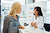 Woman discussing product with pharmacist