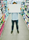 Man holding blank card aisle