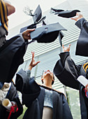 Students in gowns throwing caps