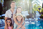 Portrait of happy family by swimming pool