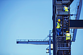 Workers climbing cargo crane