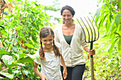 Girl and woman with gardening fork