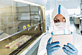 Scientist in clean suit using tablet