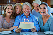 Mature men and women with birthday cake