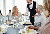 Waiter serving fancy dish to woman