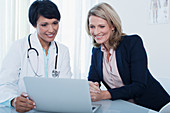 Doctor and patient using laptop