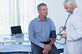 Doctor taking patient's blood pressure