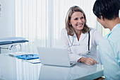 Smiling female doctor and woman at desk