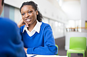 Smiling teenage student at desk in school
