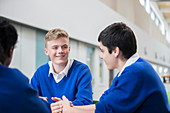 Three male students talking in corridor