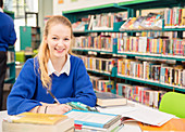 Schoolgirl doing homework in library
