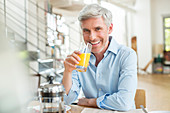 Older man drinking orange juice