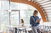 Businesswoman using tablet in cafeteria