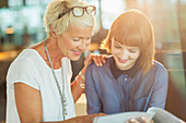 Businesswomen reading paperwork in office