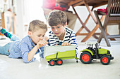 Brothers playing with toy tractor
