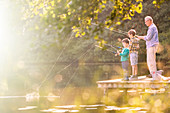 Grandfather and grandsons fishing at lake