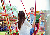 Mother and daughter playing on swing