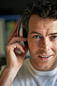 Smiling man with headphones on, close up