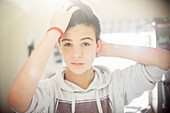 Portrait of teenage boy with hand in hair