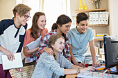 Group of teenagers using computer in room