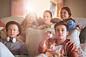 Group of teenagers watching tv on sofa