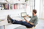 Man sitting with legs working with laptop
