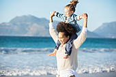 Mother carrying daughter on her shoulders