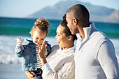 Happy family giving high five on beach