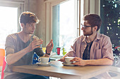 Men talking and drinking coffee in cafe