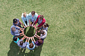 Team connected in circle in field