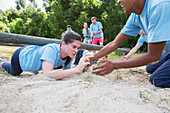 Teammate helping woman crawling