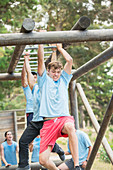 Determined man crossing monkey bars