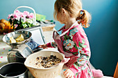 Girl with tablet baking in kitchen