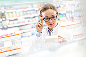 Pharmacist reading label on box