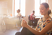 Smiling Businesswoman texting in office